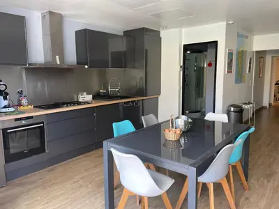 a kitchen with a dining room table and chairs at Vacances de rêve à Propriano Grand appartement avec jardin Vue sur le golfe in Viggianello