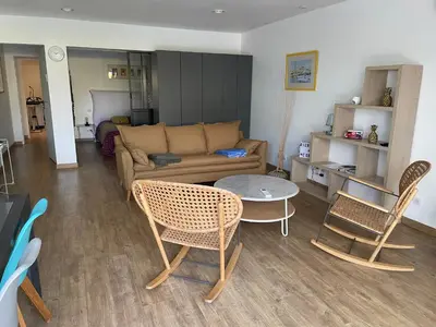 a living room with a couch and a table and chairs at Vacances de rêve à Propriano Grand appartement avec jardin Vue sur le golfe in Viggianello