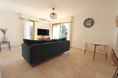 a living room with a couch and a table at Sublime Appartement avec Parking sur Ajaccio in Ajaccio