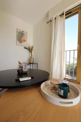 a living room with a table and a large window at Sublime Appartement avec Parking sur Ajaccio in Ajaccio