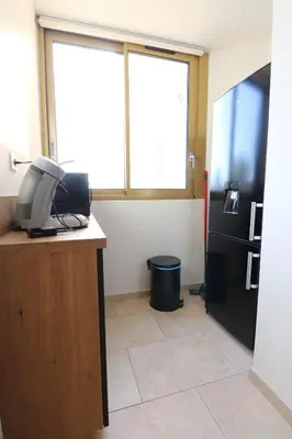 a office with a refrigerator and a phone on a desk at Sublime Appartement avec Parking sur Ajaccio in Ajaccio