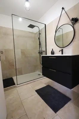 a bathroom with a shower with a sink and a mirror at Sublime Appartement avec Parking sur Ajaccio in Ajaccio