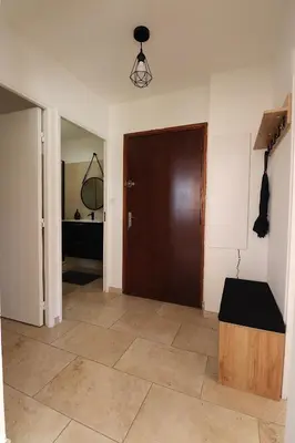 a hallway with a brown door and a room at Sublime Appartement avec Parking sur Ajaccio in Ajaccio