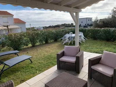 a patio with chairs and a table in a yard at Villa Costa Verde in Cervione