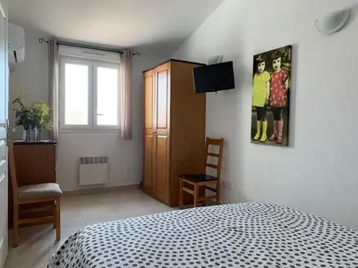 a bedroom with a bed and a painting on the wall at Villa Costa Verde in Cervione