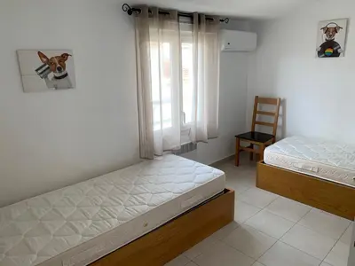 two beds in a room with a window and a chair at Villa Costa Verde in Cervione