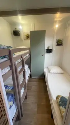 a small room with two bunk beds and a door at Chalet climatisé en Haute-Corse 500m plage - camping Marina di Sorbo in Sorbo-Ocagnano