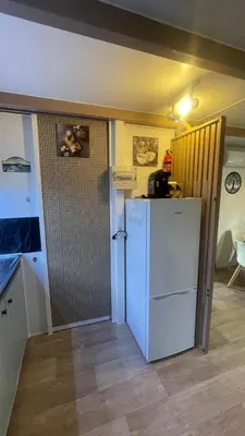 a kitchen with a white refrigerator in a room at Chalet climatisé en Haute-Corse 500m plage - camping Marina di Sorbo in Sorbo-Ocagnano