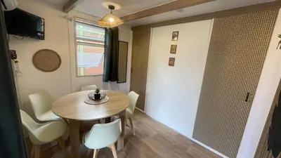 a small dining room with a table and chairs at Chalet climatisé en Haute-Corse 500m plage - camping Marina di Sorbo in Sorbo-Ocagnano