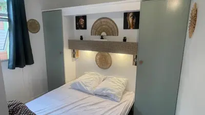 a small bedroom with a bed and a sink at Chalet climatisé en Haute-Corse 500m plage - camping Marina di Sorbo in Sorbo-Ocagnano