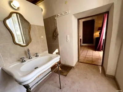 a bathroom with a sink and a mirror at Maison de maître en pierre de 1831 avec vue sur la mer à Porticcio in Porticcio