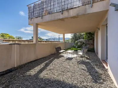 a patio with chairs and a balcony on a building at Holiday Home Casa Caminu by Interhome in Porto-Vecchio
