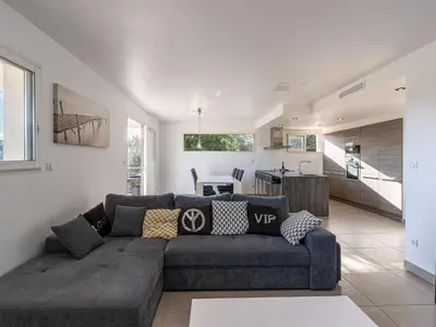a living room with a couch and a kitchen at Holiday Home Casa Caminu by Interhome in Porto-Vecchio