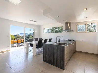a kitchen with a sink and a table with chairs at Holiday Home Casa Caminu by Interhome in Porto-Vecchio