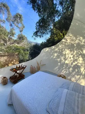 a bedroom with a bed and a view of a forest at Bulle du Fangu in Galeria