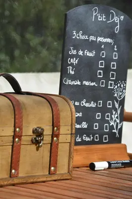 a chalkboard sign and a suitcase on a table at Bulle du Fangu in Galeria