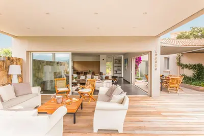 a living room with white furniture on a wooden floor at Ecrin de Pinarello in Pinarellu