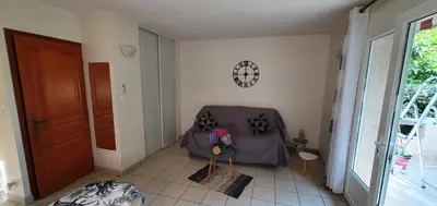 a room with a chair and a clock on the wall at Studio 30 m2 climatisé calme in Eccica-Suarella