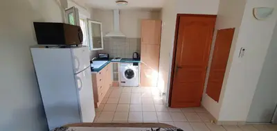 a kitchen with a refrigerator and a washing machine at Studio 30 m2 climatisé calme in Eccica-Suarella