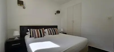 a bedroom with a white bed with two pillows at T2 Dolce & Vita C3 vue mer et piscine in Propriano
