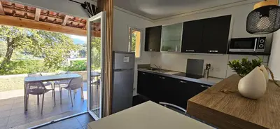 a kitchen with a table and a dining room at T2 Dolce & Vita C3 vue mer et piscine in Propriano