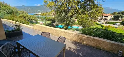 a table and chairs on a balcony with a view of a pool at T2 Dolce & Vita C3 vue mer et piscine in Propriano