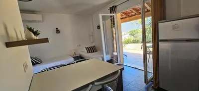 a kitchen with a counter and a refrigerator in a room at T2 Dolce & Vita C3 vue mer et piscine in Propriano