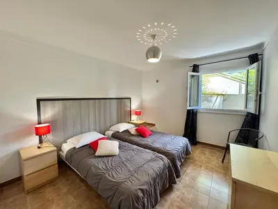 a bedroom with two beds with red pillows at Villa le Palmier 10 personnes piscine, vue mer, plage in Olmeto