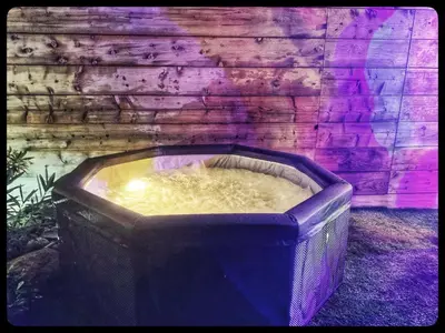 a hot tub sitting in front of a brick wall at Villa DOLCE, piscine privée chauffée & jacuzzi privatif, 5mn des plages in Porto-Vecchio