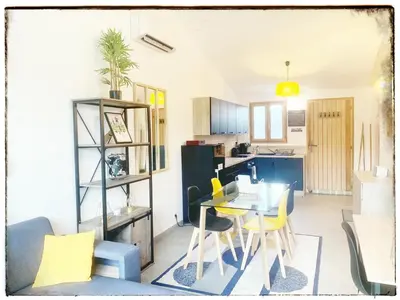 a kitchen and dining room with a table and chairs at Villa DOLCE, piscine privée chauffée & jacuzzi privatif, 5mn des plages in Porto-Vecchio