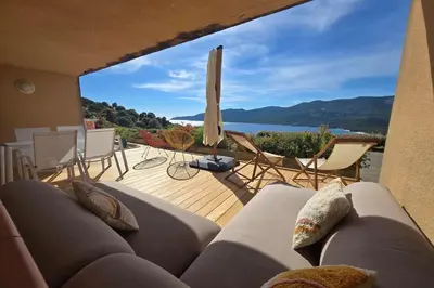 a living room with a couch and a view of the water at Bel Appartement climatisé vue imprenable sur la mer terrasse wifi in Serra-di-Ferro
