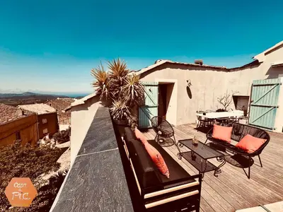 a balcony of a house with a table and chairs at Casa di Pia, demeure Corse du XIXème in Olmeta-di-Tuda