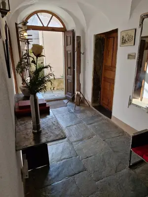 a hallway with a door and a vase on a table at Casa di Pia, demeure Corse du XIXème in Olmeta-di-Tuda