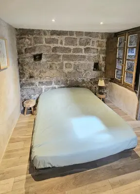 a large bed in a room with a brick wall at Appartement vue imprenable montagne in Serra-di-Scopamene