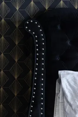 a black leather couch with a black and gold wallpaper at Hacienda d Amore in Oletta