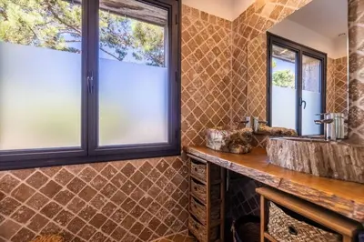 a bathroom with a sink and two windows at Villa Cala Rossa pieds dans l'eau Porto-Vecchio in Lecci