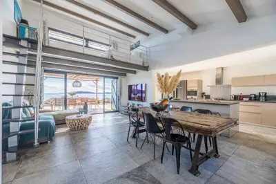 a kitchen and dining room with a table and chairs at Villa Cala Rossa pieds dans l'eau Porto-Vecchio in Lecci