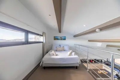 a small bedroom with a bed and a window at Villa Cala Rossa pieds dans l'eau Porto-Vecchio in Lecci