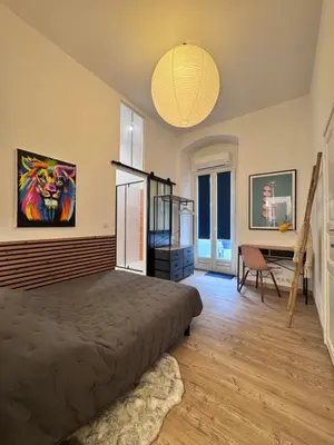 a bedroom with a bed and a painting on the wall at A Casa Grandval - Ajaccio in Ajaccio