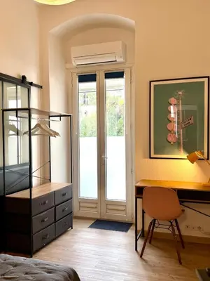 a bedroom with a desk and a bed with a dresser at A Casa Grandval - Ajaccio in Ajaccio
