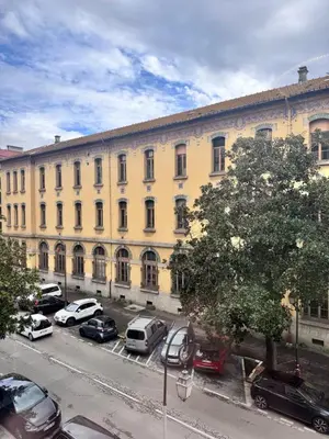 a large building with cars parked in a parking lot at A Casa Grandval - Ajaccio in Ajaccio