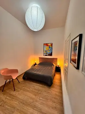 a bedroom with a bed and a chandelier at A Casa Grandval - Ajaccio in Ajaccio