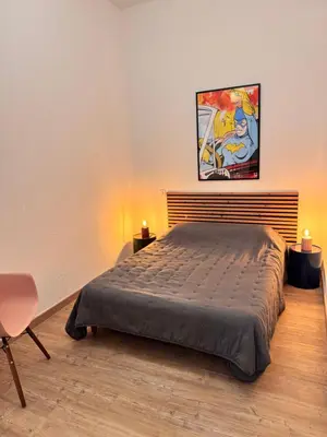 a bedroom with a bed and a painting on the wall at A Casa Grandval - Ajaccio in Ajaccio