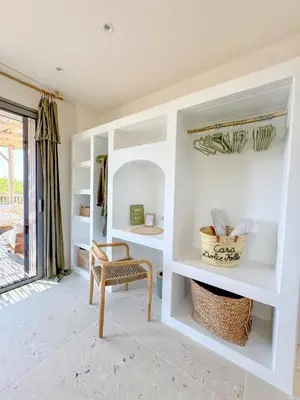 a room with white shelves and a chair at Bohemian Villa with Heated Pool near beach in Lecci