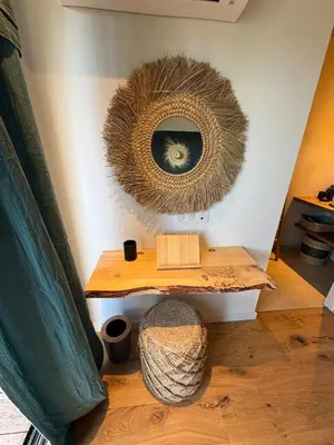 a mirror hanging on a wall with a wooden table at Bohemian Villa with Heated Pool near beach in Lecci