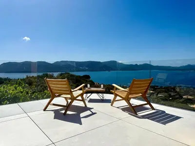 two chairs and a table on a patio with a view at Villa Altezza - vue mer 270° in Porto-Vecchio