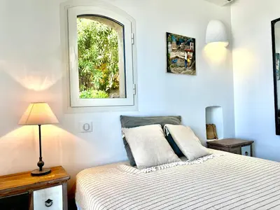 a bedroom with a bed and a window at Villa Altezza - vue mer 270° in Porto-Vecchio