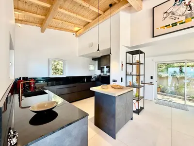 a kitchen with white walls and a wooden ceiling at Villa Altezza - vue mer 270° in Porto-Vecchio