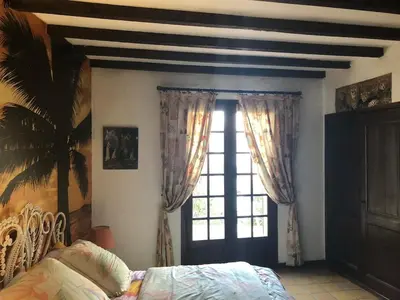 a bedroom with a bed and a large window at Maison familiale vue mer in Grosseto-Prugna
