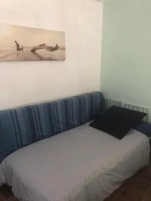 a bed in a room with a picture on the wall at Maison familiale vue mer in Grosseto-Prugna